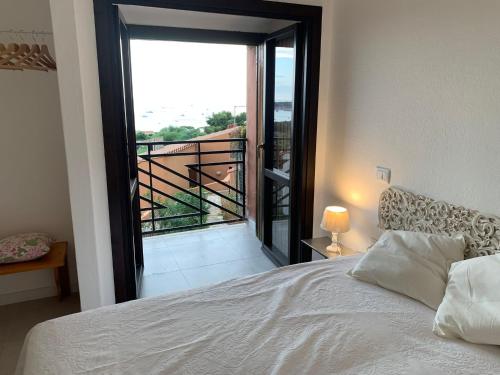 a bedroom with a bed and a view of a balcony at Villasimius Il patio sul porto in Villasimius