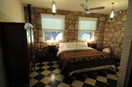 1 dormitorio con cama y pared de piedra en La Aguada Hotel Boutique de Montana en Coneta