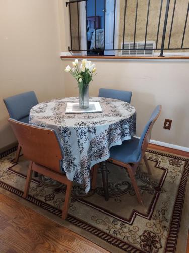 a dining room table with a vase of flowers on it at The Paradise @ Lyncott in Lansing