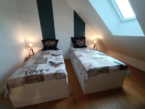 a bedroom with two beds in a attic at Petit Coin de Beauce in Toury