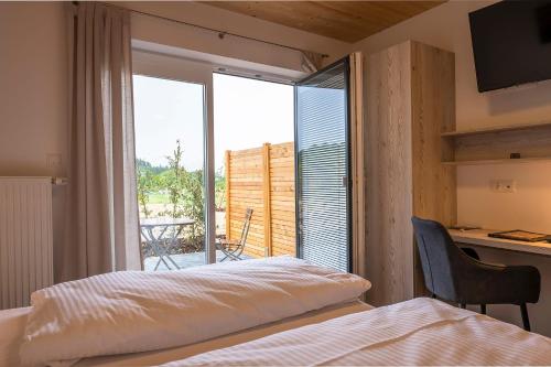 Schlafzimmer mit einem Bett und Blick auf einen Balkon in der Unterkunft Familiengasthof Schaller in Floß