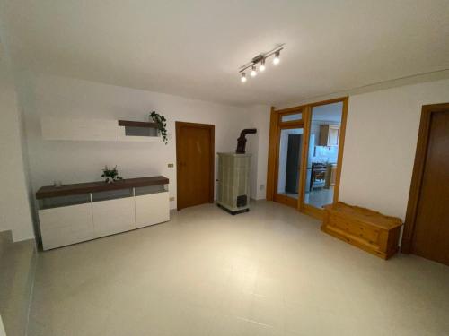 uma sala de estar vazia com uma cozinha e um fogão em Appartamento Degasperi em Fiavè