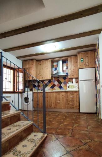 a kitchen with wooden cabinets and a refrigerator at Finca La Celada in Moratalla