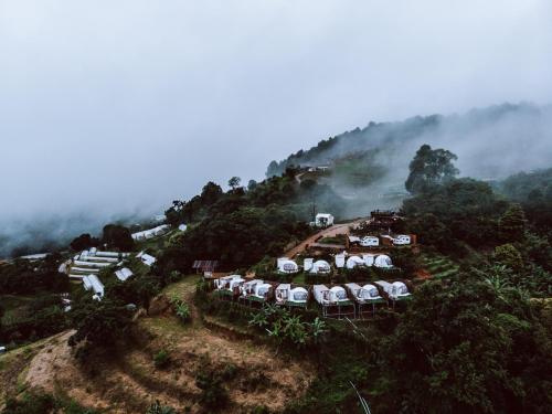 a group of tents on a hill in the mist at Phu Morinn Cafe &Camping Monjam in Mon Jam