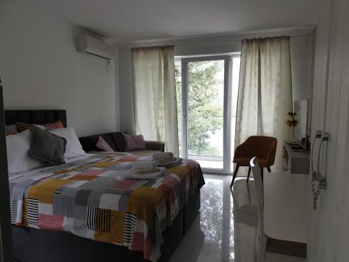a bedroom with a bed and a large window at Apartman tipa studio BMB in Veliko Gradište