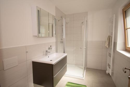 a white bathroom with a sink and a shower at Ferienwohnungen Lexahaus in Liesing