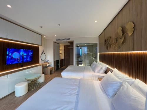 a bedroom with two beds and a flat screen tv at Apec Mandala Phú Yên Hương Giang Condotel in Liên Trì (3)