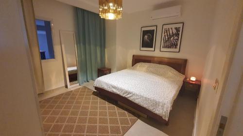 a bedroom with a bed and a window and a chandelier at Soma Bay Ambiance - Relaxed Apartment - Next to The Breakers in Hurghada