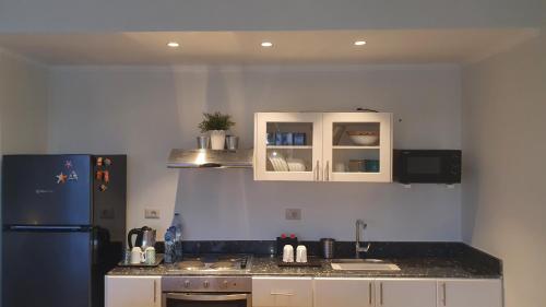 a kitchen with white cabinets and a blue refrigerator at Soma Bay Ambiance - Relaxed Apartment - Next to The Breakers in Hurghada