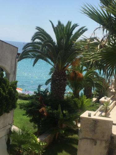 a view of the ocean from a resort with palm trees at FRENKI APARTMENT BY THE SEA in Siviri