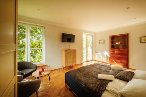 sypialnia z łóżkiem, krzesłem i oknami w obiekcie Orkana 13 Apartments w Zakopanem