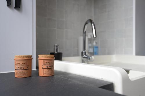 two cups of coffee sitting on a counter next to a sink at Vakantiehuis huYze-K in Zottegem