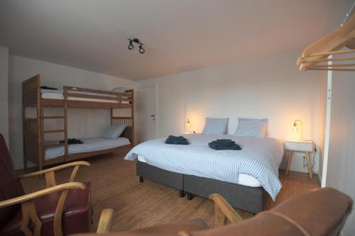een slaapkamer met 2 bedden en een stapelbed bij Vakantiehuis huYze-K in Zottegem