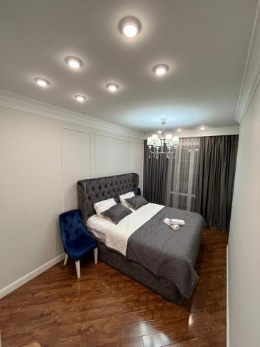 um quarto com uma cama e uma cadeira azul em Apartments in the Babylon residential complex em Almaty
