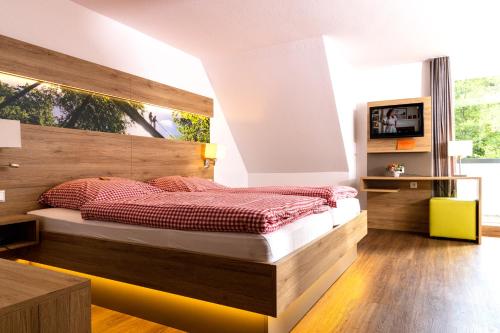 - une chambre avec un grand lit et une tête de lit en bois dans l'établissement Hotel & Gasthof Hubertushöhe - Ihr Hotel für Urlaub mit Hund, à Schmallenberg