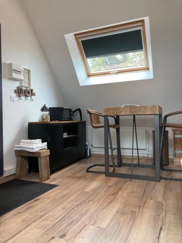 uma sala de estar com uma mesa e uma janela em Studio Escapade Normande proche Etretat em Saint-Jouin-Bruneval