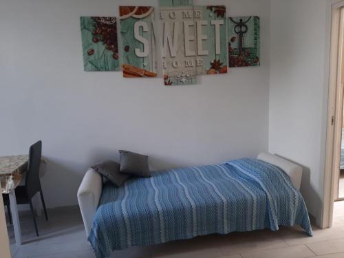 a bedroom with a bed with a blue blanket and a table at Home Sweet Home in Civitavecchia