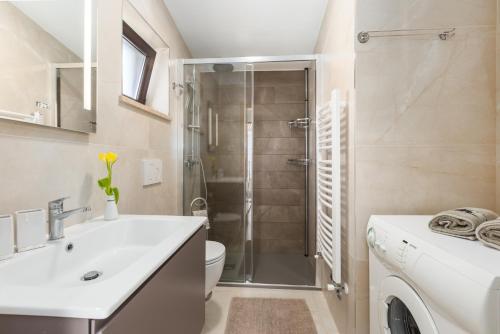een badkamer met een douche, een wastafel en een toilet bij Alex Deluxe Apartments on Beach in Poreč