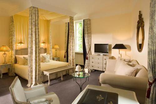 a living room with a bed and a couch and a tv at Weinromantikhotel Richtershof in Mülheim an der Mosel