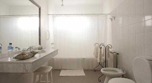 a white bathroom with a tub and a sink and a toilet at La Merced Del Alto in Cachí