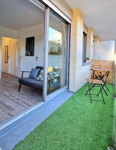 a living room with a patio with green grass at HYPER CENTRE Gare RER A 250m Paris 20min in Poissy