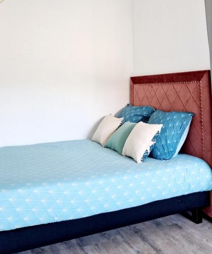 a bed with blue sheets and pillows on it at HYPER CENTRE Gare RER A 250m Paris 20min in Poissy