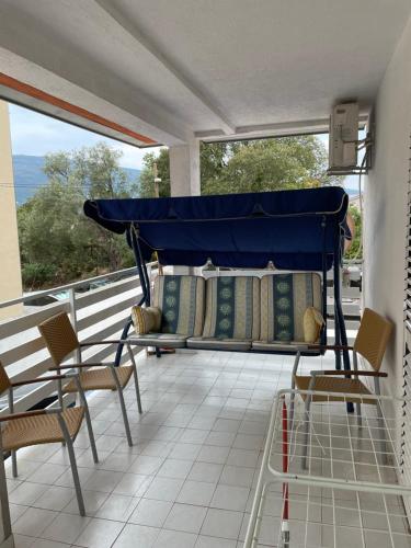 a porch with a bed and chairs on a balcony at Apartman Lucy in Baošići