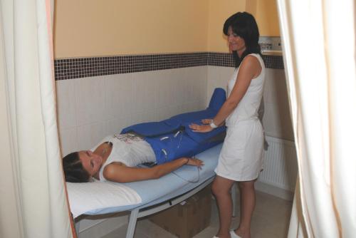 a woman standing next to a man on a bed at Aqua Marina in Karlovy Vary
