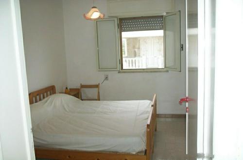 ein kleines Schlafzimmer mit einem Bett und einem Fenster in der Unterkunft Casa posto vecchio in Salve