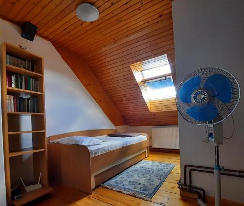 a bedroom with a bed and a book shelf and a fan at Apartman Glomazic in Žabljak