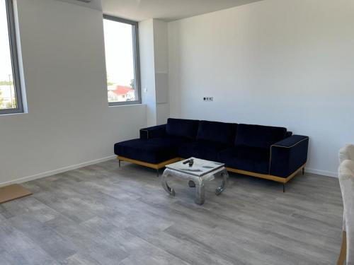 Sala de estar con sofá azul y mesa de centro en Loft épuré avec parking privé. en Saint-Symphorien-dʼOzon