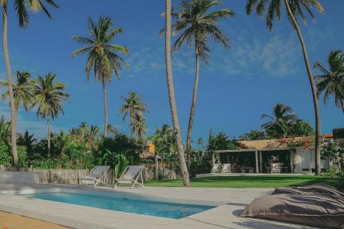 una villa con piscina y palmeras en Depraia Beach House - Icaraizinho, en Icaraí