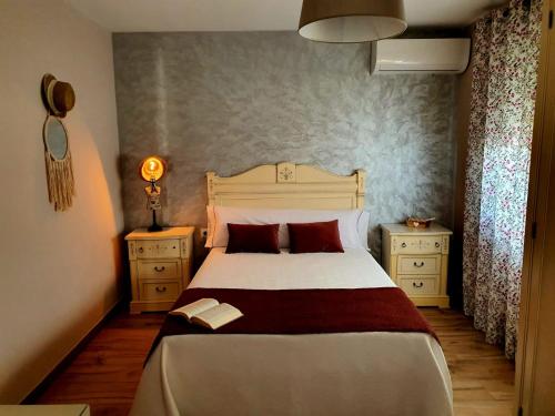 een slaapkamer met een groot bed en 2 nachtkastjes bij El lazarillo de tormes in Escalona
