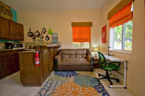 a kitchen with a couch and a desk in a room at BELIZE TROPICAL DREAM VILLAS in San Pedro