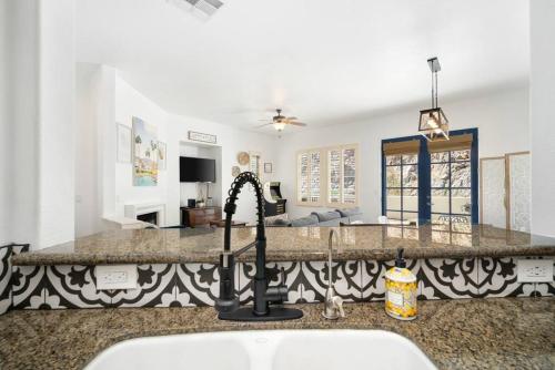 a kitchen with a sink and a living room at Legacy Villas private 3 bedroom 3 bath villa with view, steps to pool, bikes and arcade game included in La Quinta