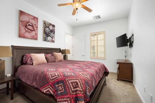 a bedroom with a bed and a ceiling fan at Legacy Villas private 3 bedroom 3 bath villa with view, steps to pool, bikes and arcade game included in La Quinta