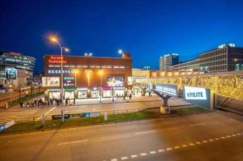 a city at night with people walking on a street at Penzion Expo Dream #33 by Goodnite cz in Brno