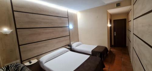 a room with two beds and a wall at Hotel La Rad in Galindo y Perahuy