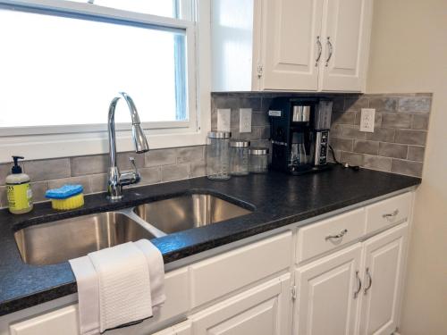 eine Küchentheke mit einem Waschbecken und einem Fenster in der Unterkunft Subtle comfort and style in quiet neighborhood. in Joplin
