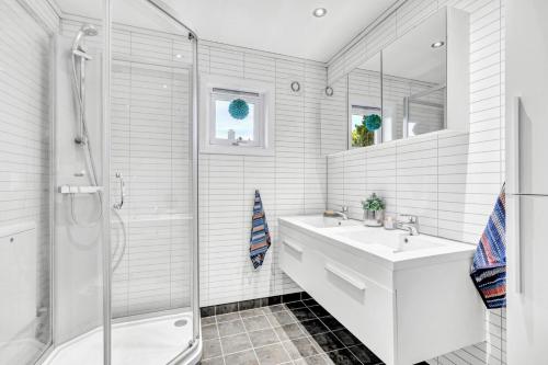 a white bathroom with a sink and a shower at private room in shared apartment in Trondheim