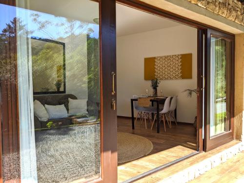 eine Glasschiebetür, die auf eine Terrasse mit einem Tisch führt in der Unterkunft Silverstone Lodge in Mbabane