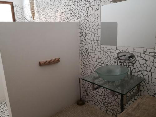 a bathroom with a sink and a mirror on a wall at Grande maison en bordure de plage in Palmarin