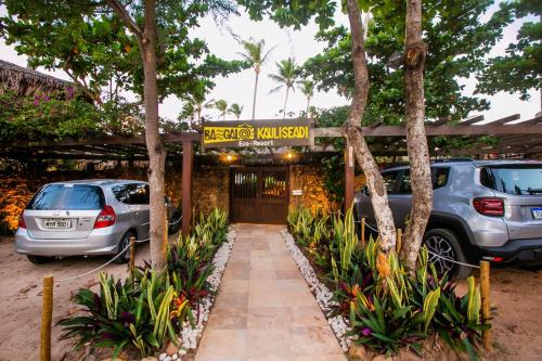 聖米格爾－杜戈斯托蘇的住宿－Bangalô Kauli Seadi Eco-Resort，大楼前停有两辆车的停车场