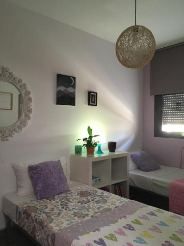 1 dormitorio con 2 camas y espejo en Alquiler casa veraneo Málaga Valleniza, en Málaga