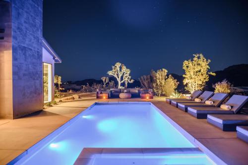 un patio trasero con piscina por la noche en Amaru Muru - Luxury Retreat with Pool/Hot Tub/Yoga en Joshua Tree