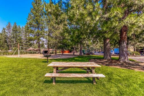 a wooden picnic table in a park with trees at Alpine Escape in Bend