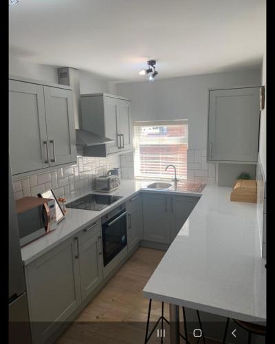 a kitchen with white cabinets and a counter top at Beautiful Room in Apartment near Town Centre in Rugby