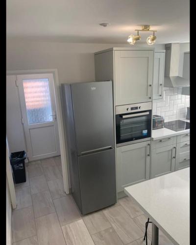a kitchen with a stainless steel refrigerator and a window at Beautiful Room in Apartment near Town Centre in Rugby