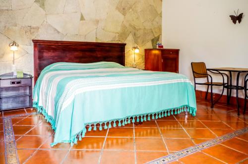 een slaapkamer met een bed en een tafel en stoelen bij Villas Xänthe Rotamundos in Huasca de Ocampo