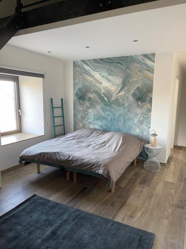 um quarto com uma cama com um quadro na parede em Les Quartiers d'Urbain em Nollevaux